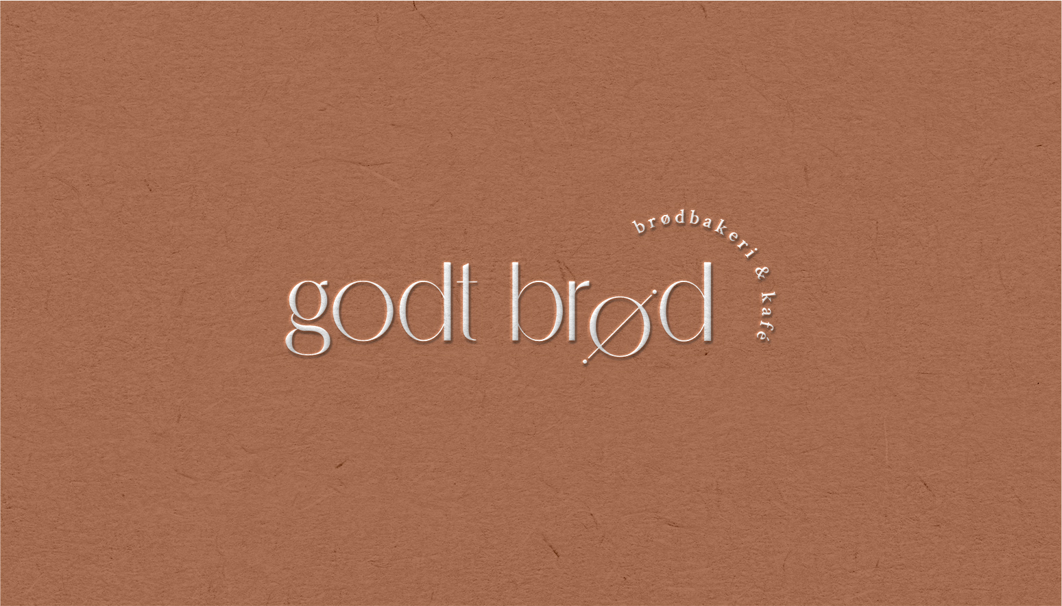 Close up of a burnt orange business card with the Godt Brod logo in the middle