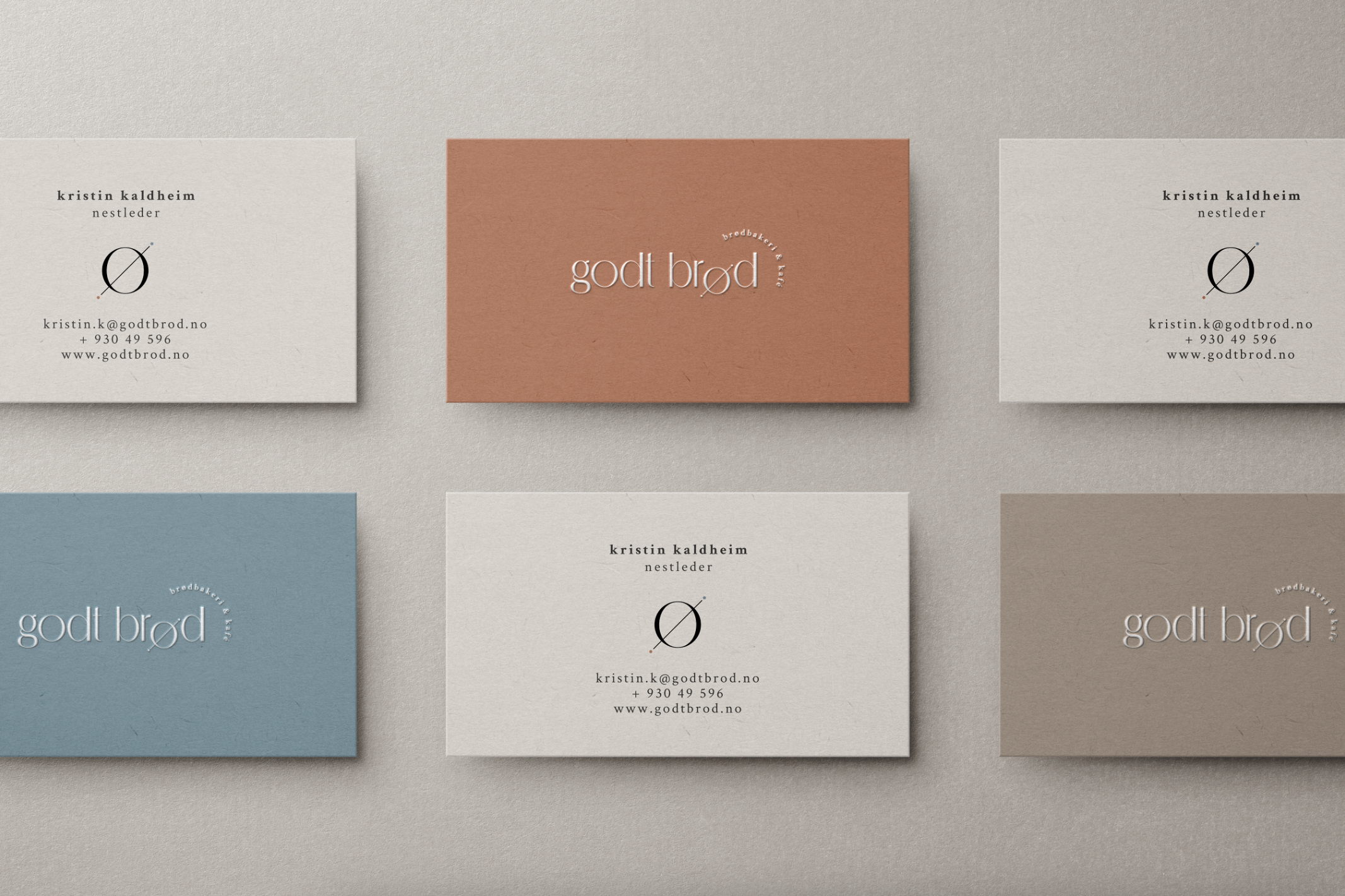 Six Godt Brod business cards in muted blue, burnt orange and beaver brown.